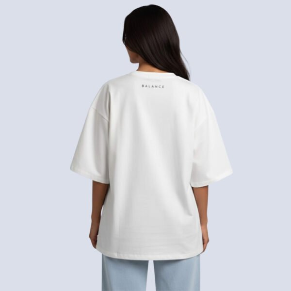 Woman wearing Asome oversized white cotton t-shirt with “Balance” printed text on chest.