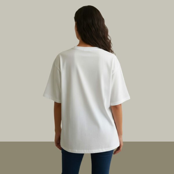 Woman wearing Asome oversized white cotton t-shirt with “Less is More” print on front.