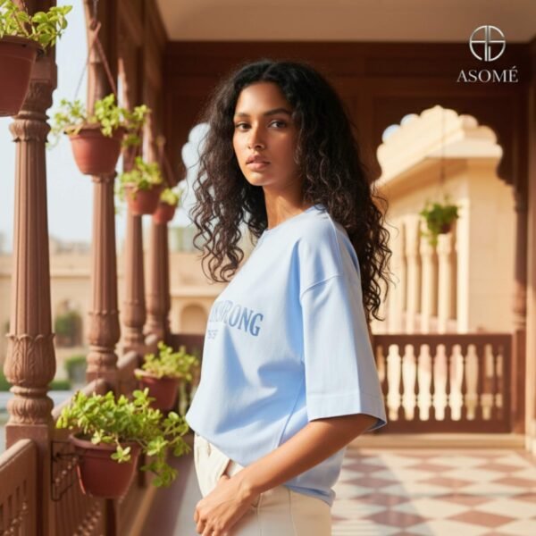 Woman in ASOMÉ blue oversized T-shirt with statement text print.