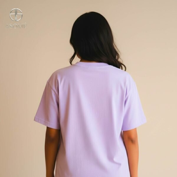 Woman in lavender oversized ASOMÉ T-shirt with chest print.