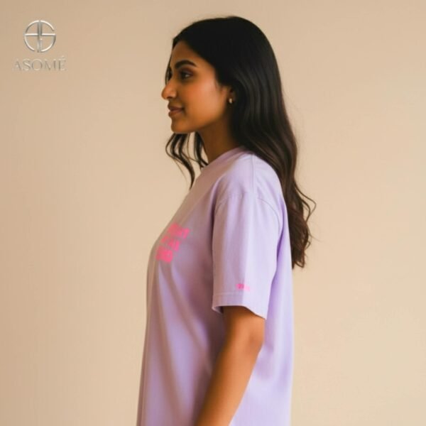 Woman in lavender oversized ASOMÉ T-shirt with chest print.